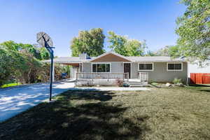 View of front of house with a deck and a front yard