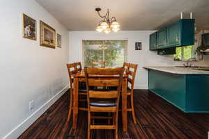 Dining room featuring a wealth of natural light, a chandelier, dark hardwood / wood-style floors, and sink