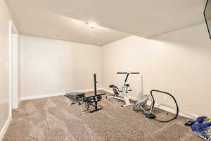 Workout room with carpet floors and a textured ceiling