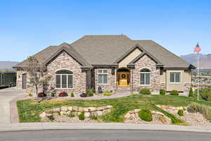 French provincial home featuring a mountain view, a front lawn, and a garage