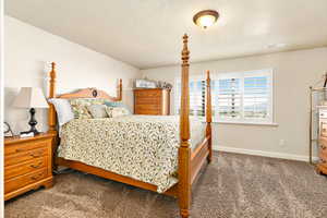 Carpeted bedroom with a textured ceiling