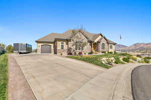 View of front of house with a garage, a mountain view, and a front yard