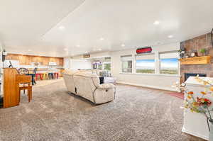 Living room featuring carpet, a fireplace, and a wealth of natural light