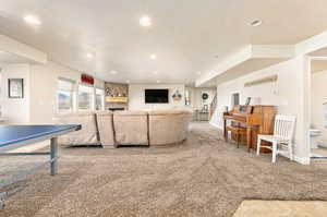 Carpeted living room with a textured ceiling and a stone fireplace