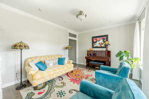 Living room featuring ornamental molding and hardwood / wood-style floors