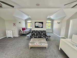 Bedroom featuring lofted ceiling, ceiling fan, and carpet flooring