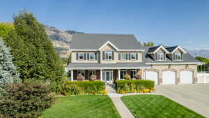 View of front of house with covered porch, a mountain view, and a front yard