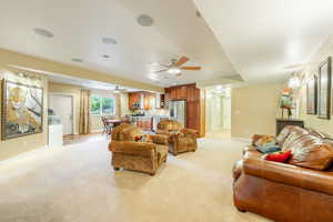 Carpeted living room with ceiling fan