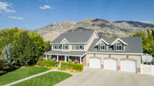 View of front of property with a mountain view, a garage, and a front lawn