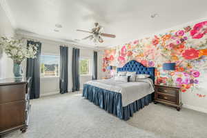 Carpeted bedroom featuring ceiling fan and crown molding