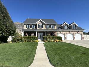 View of front of property featuring a front yard, a garage, and a porch