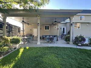 Back of property featuring a patio, a yard, and ceiling fan