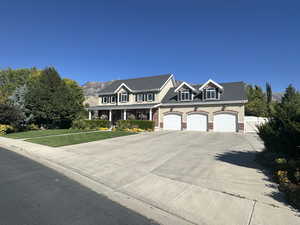 View of front of house featuring a garage, a mountain view, and a front lawn