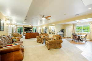 Living room with ceiling fan and light tile patterned flooring