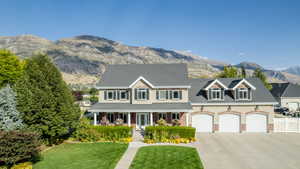 View of front of house with a mountain view, a garage, a front lawn, and covered porch