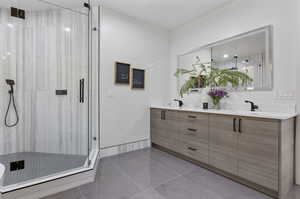 Bathroom with walk in shower, tile patterned flooring, and vanity