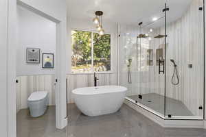 Bathroom with separate shower and tub, toilet, and tile patterned floors