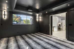 Home theater with a raised ceiling and crown molding