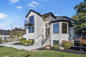 View of front facade with a balcony and a front yard