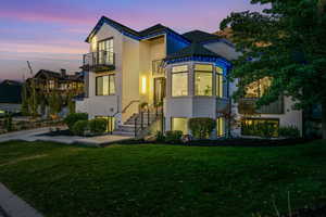 View of front of home with a balcony and a yard