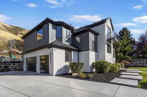 View of side of home with a balcony, a mountain view, and a garage