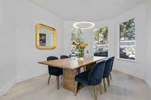 Dining room with light hardwood / wood-style floors and crown molding