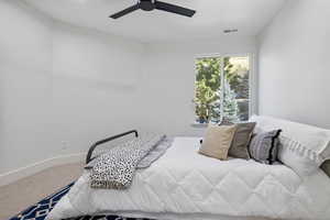 Carpeted bedroom with ceiling fan