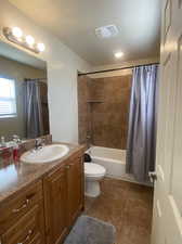 Master bathroom for King Suite 2 with vanity, tile patterned floors, toilet, and shower / tub combo with curtain