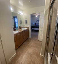 Master Bathroom for King Suite 1 featuring walk in shower, vanity, ceiling fan, and tile patterned floors