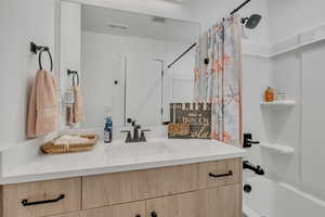 Full bathroom with vanity and shower / bath combination with upgraded cabinets