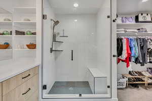 Beautiful oversized walk-in shower with custom shelving and bench seat