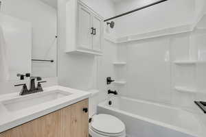 Full bath featuring vanity and bathing tub / shower combination