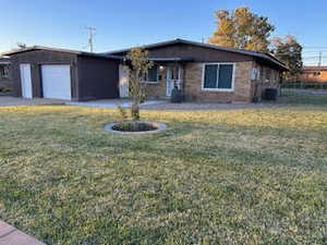 Ranch-style home with a front yard and a garage