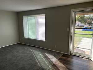 Formal front room with a textured ceiling lush gray carpet and LVP flooring in the entrance