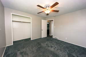 #2 Bedroom View 1 bedroom with a textured ceiling,  newer dark Gray colored carpet, ceiling fan, and a closet