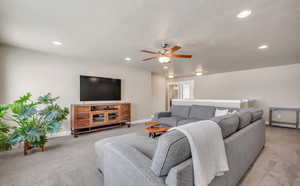 Carpeted living room featuring ceiling fan