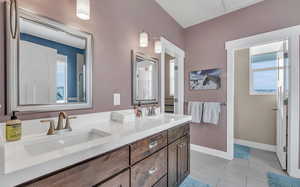 Bathroom with a wealth of natural light, tile patterned flooring, and vanity