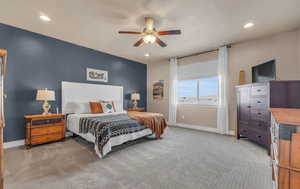 Carpeted bedroom featuring ceiling fan