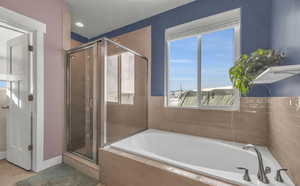 Bathroom featuring shower with separate bathtub and tile patterned floors