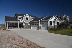 Craftsman house featuring a front yard, a garage, and covered porch