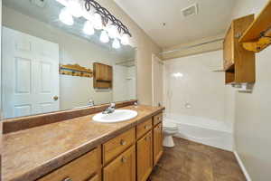 Full bathroom featuring bathtub / shower combination, tile patterned floors, vanity, and toilet