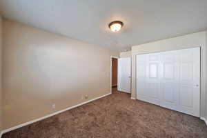 Unfurnished bedroom with a closet and carpet flooring