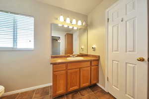 Bathroom with vanity, toilet, ceiling fan, and tile patterned floors