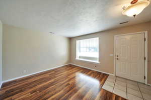 Entrance foyer featuring a textured ceiling and dark hardwood / wood-style flooring