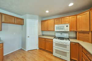 Kitchen featuring white appliances and light hardwood / wood-style floors