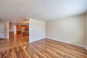 Unfurnished living room with a textured ceiling and hardwood / wood-style floors