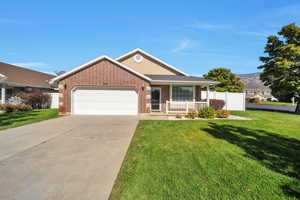 Ranch-style home with a front yard, a garage, and covered porch