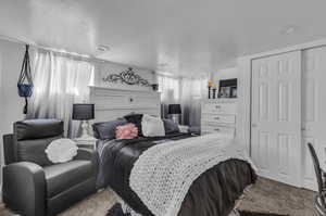 Bedroom with a closet, a textured ceiling, and carpet flooring