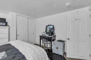 Bedroom with carpet, a closet, and a textured ceiling