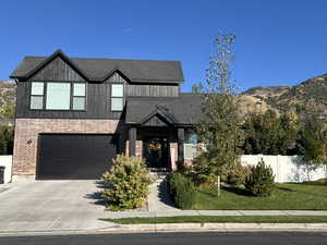 View of front of home featuring a front yard, a mountain view, and a garage